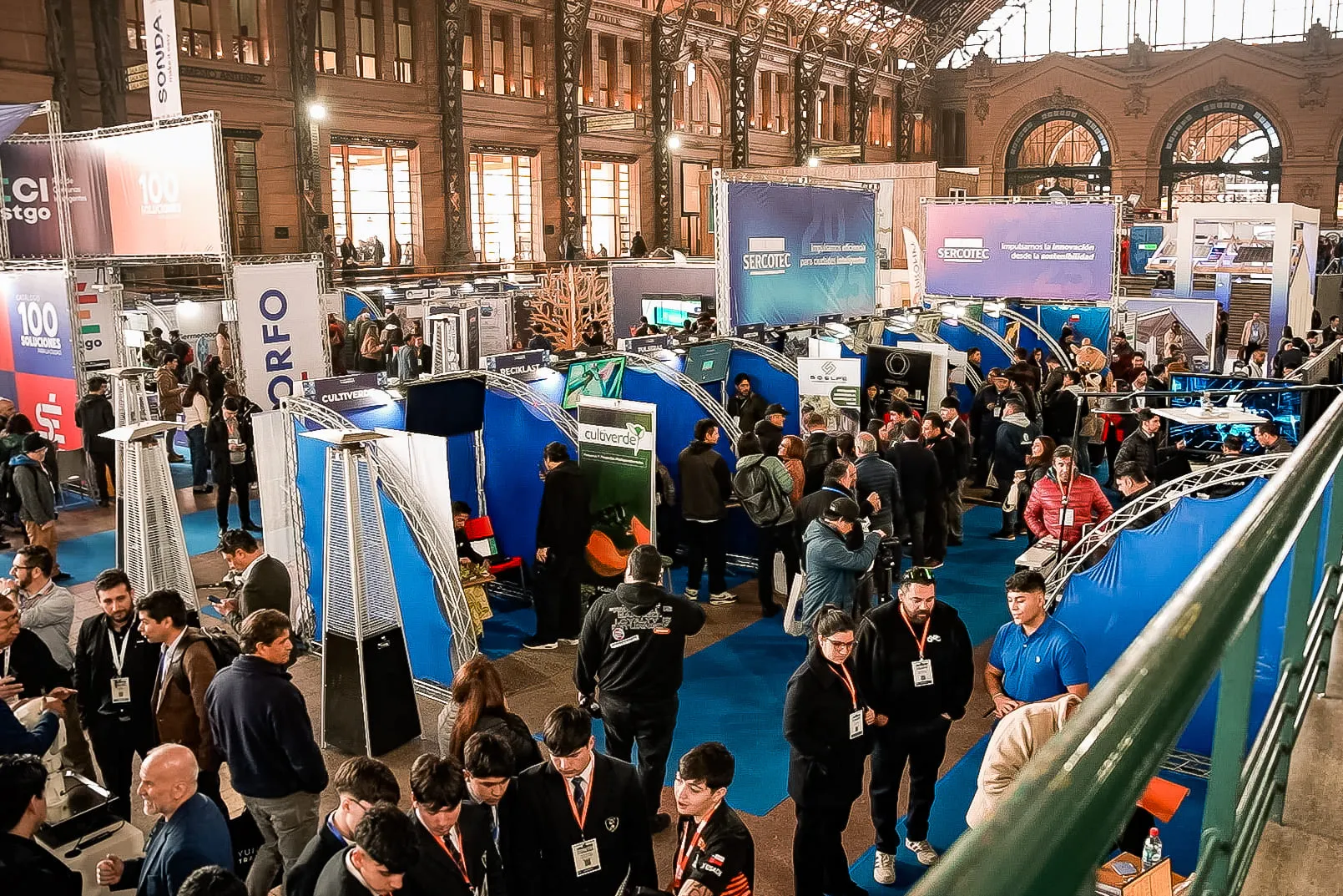Vista aérea de asistentes y stands durante una feria de innovación urbana en la Estación Mapocho.